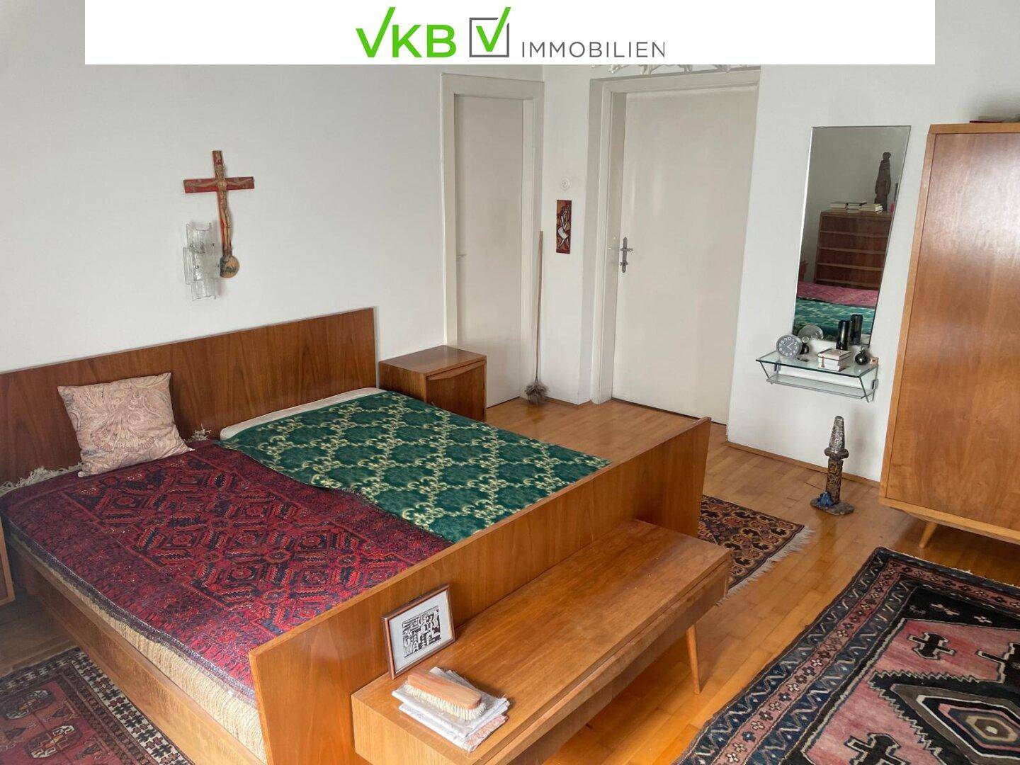 Schlafzimmer mit zwei Einzelbetten, Holzmöbeln und traditionellen Teppichen.
