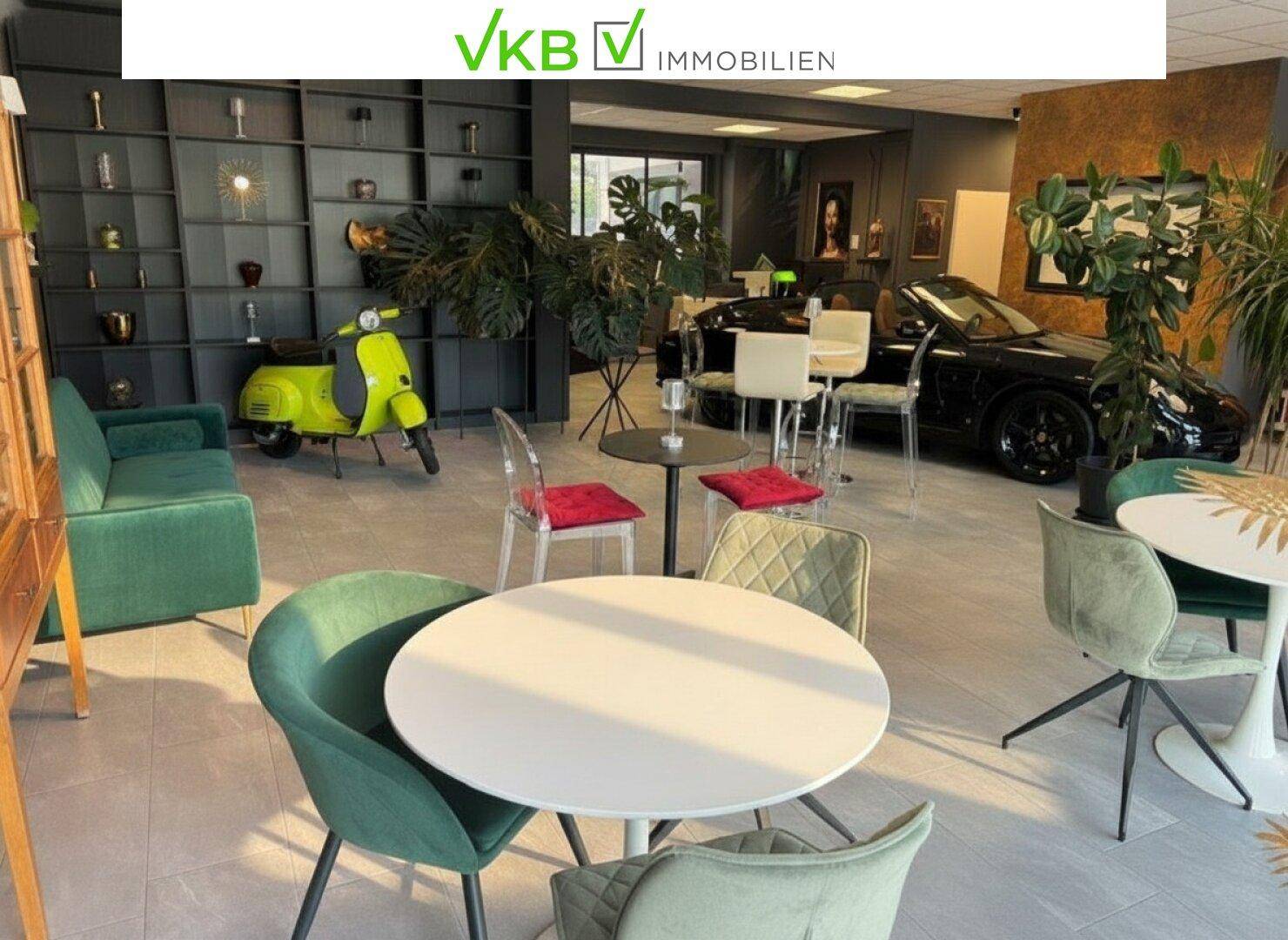 Geräumiger Loungebereich mit vielfältigen Sitzmöglichkeiten, Pflanzen und einem dekorativen Sportwagen.