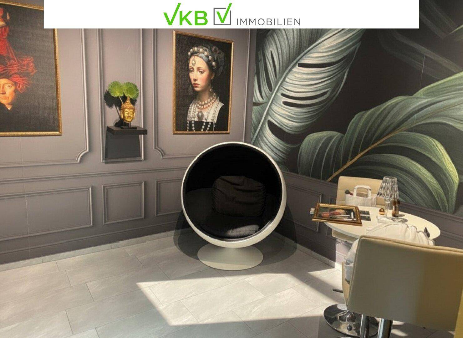 Moderner Loungebereich mit einzigartigem Kugelsessel, Kunstwerken an der Wand und stilvoller Einrichtung.