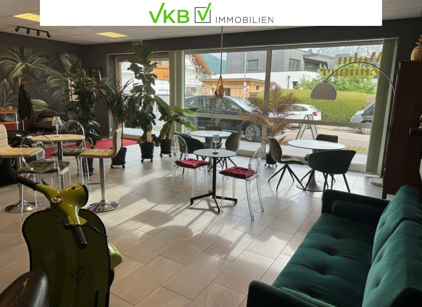 Heller Loungebereich mit großen Fenstern, Blick nach draußen und verschiedenen Sitzgruppen.