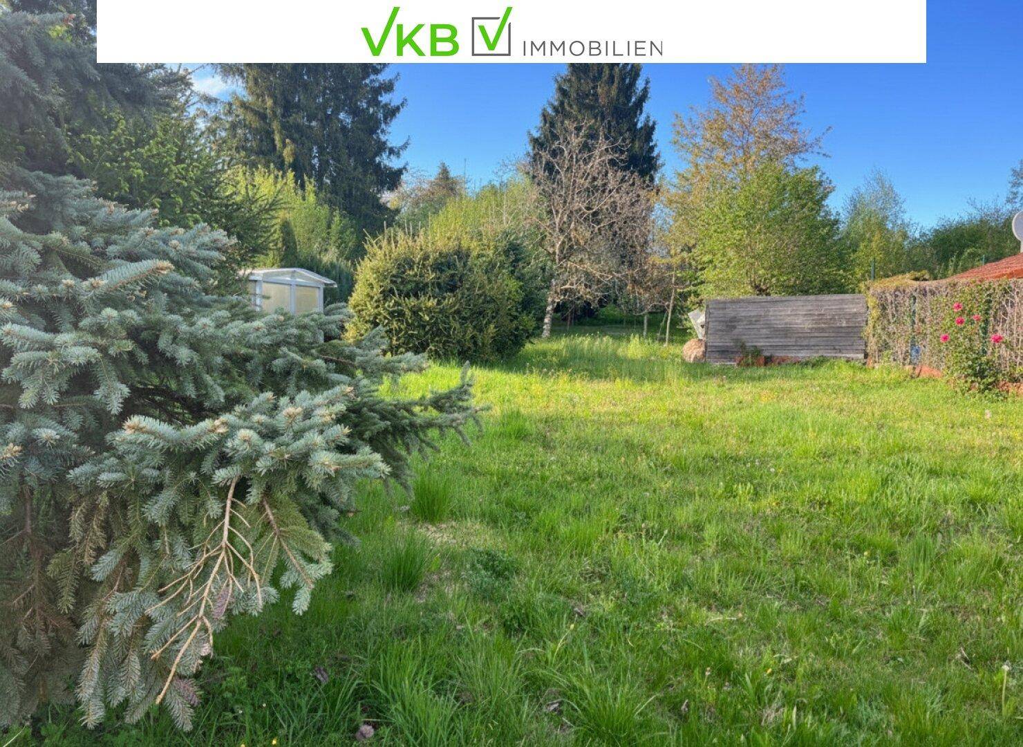 Weitläufiger Garten mit altem Baumbestand, Sträuchern und einem kleinen Geräteschuppen.