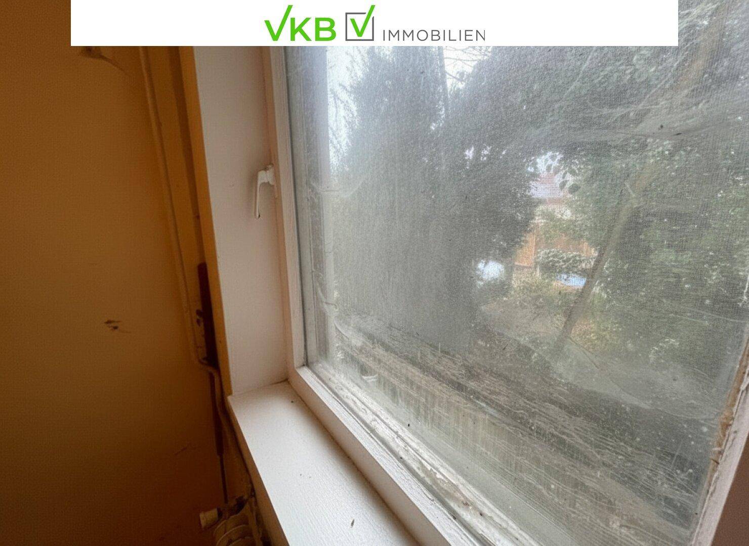 Nahaufnahme eines alten, verschmutzten Fensters mit abgenutztem Rahmen.