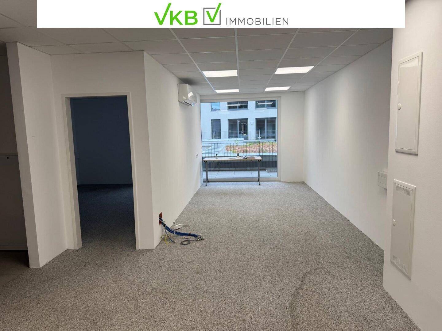 Geräumiger, leerer Bürobereich mit Teppichboden und großen Fenstern, bietet vielseitige Nutzungsmöglichkeiten.