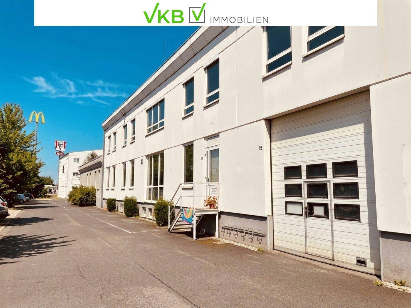 Seitenansicht eines Geschäftsgebäudes mit Laderampe und weiteren Parkplätzen im Freien.