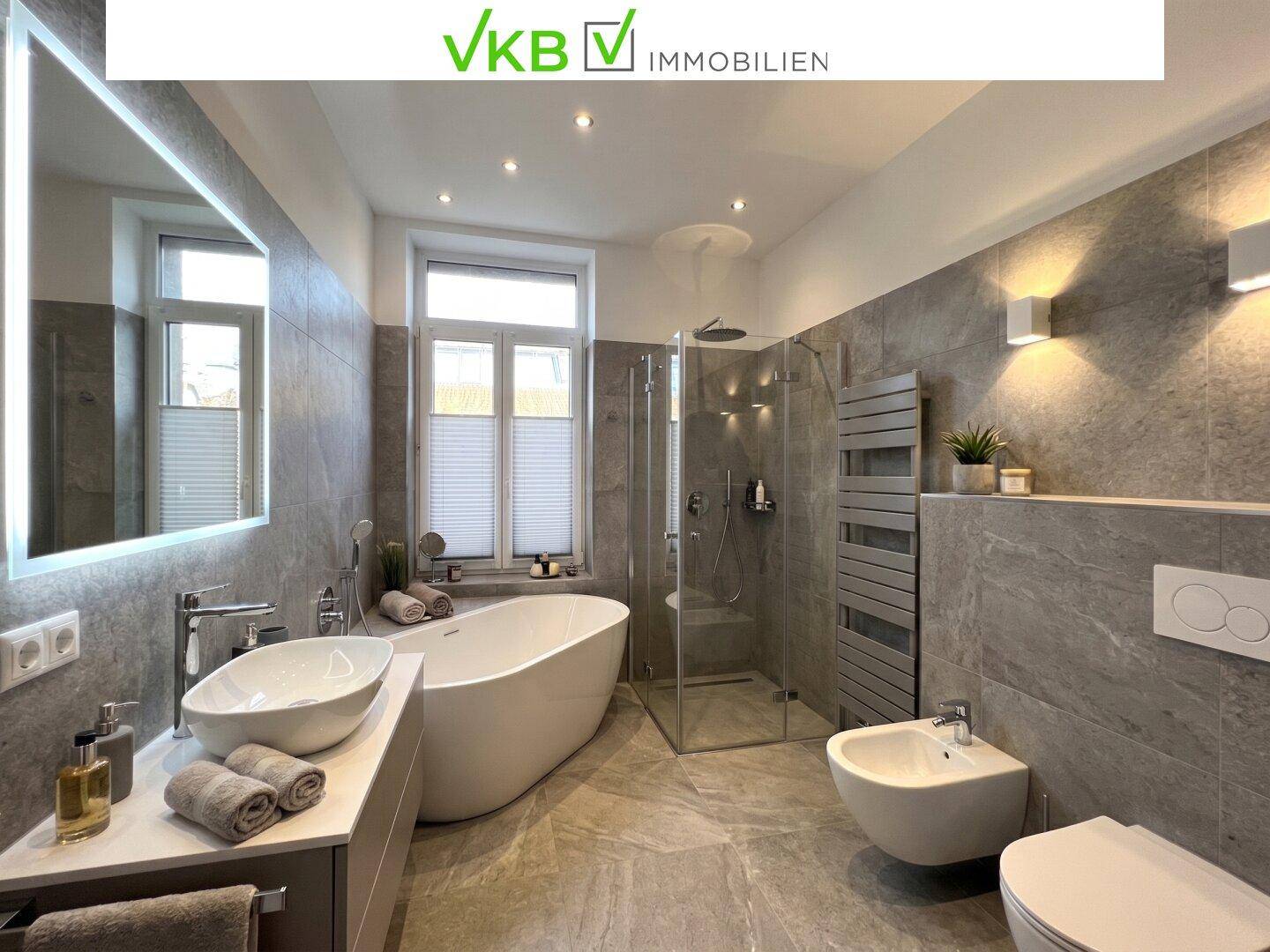 Modernes Badezimmer mit freistehender Badewanne, großer Dusche und Fenster.