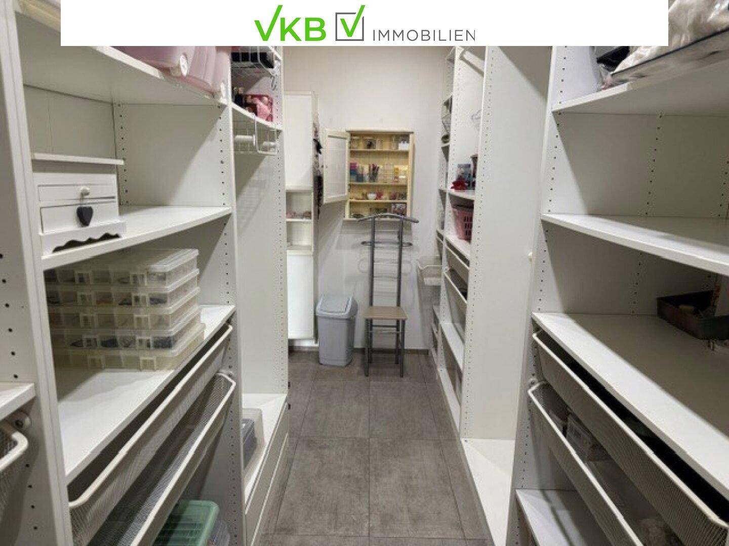 Geräumiger begehbarer Kleiderschrank mit vielen Regalen und Aufbewahrungsmöglichkeiten.