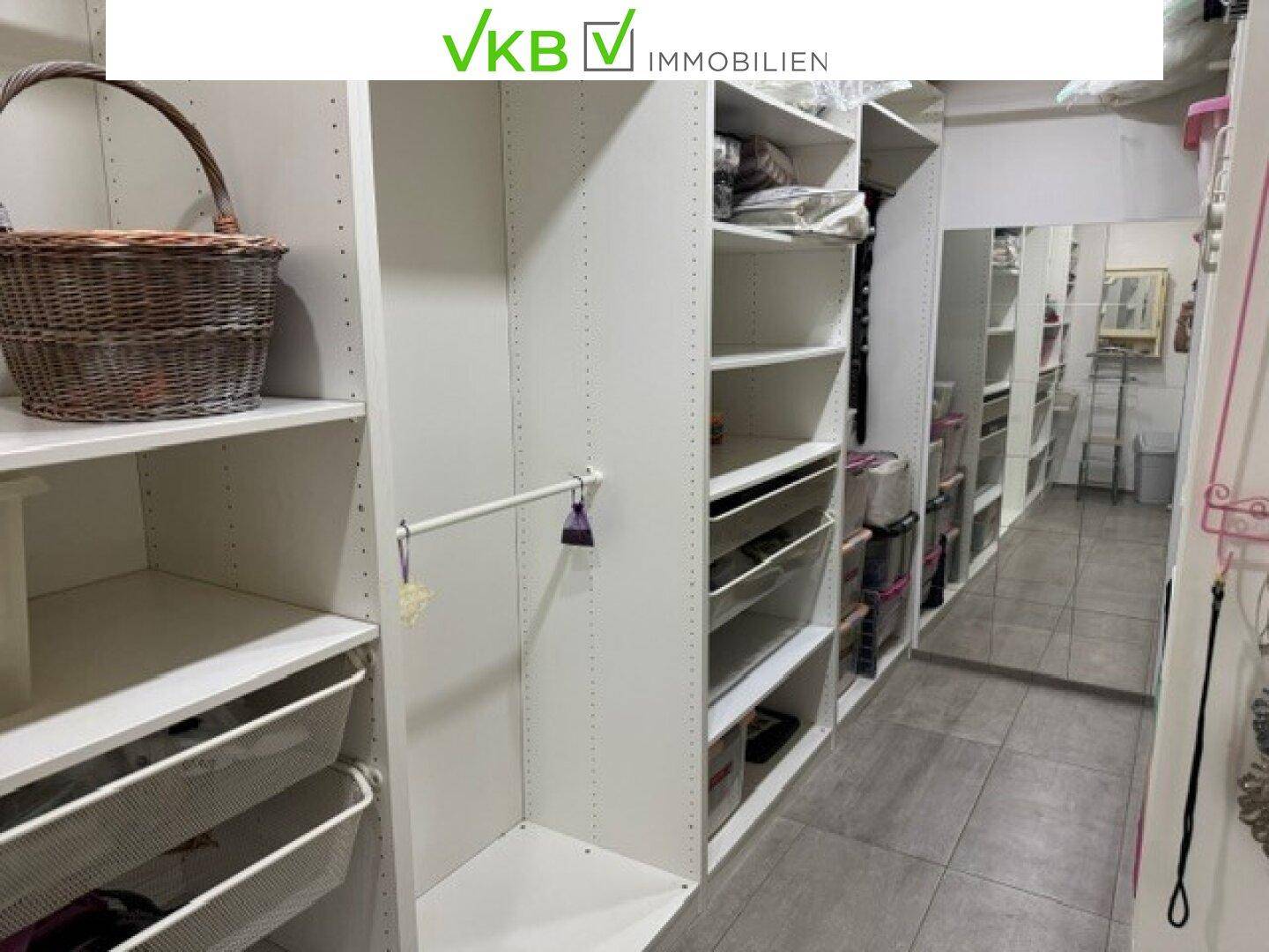 Gut organisierter begehbarer Kleiderschrank mit Spiegel und vielfältigen Ablagemöglichkeiten.
