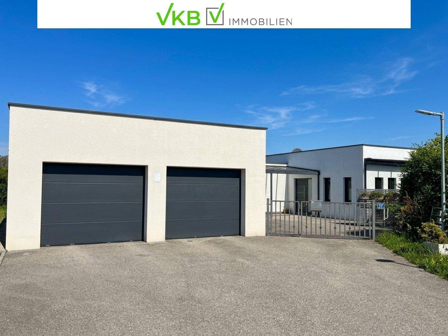 Moderne Hausfassade mit Doppelgarage und Einfahrtstor.