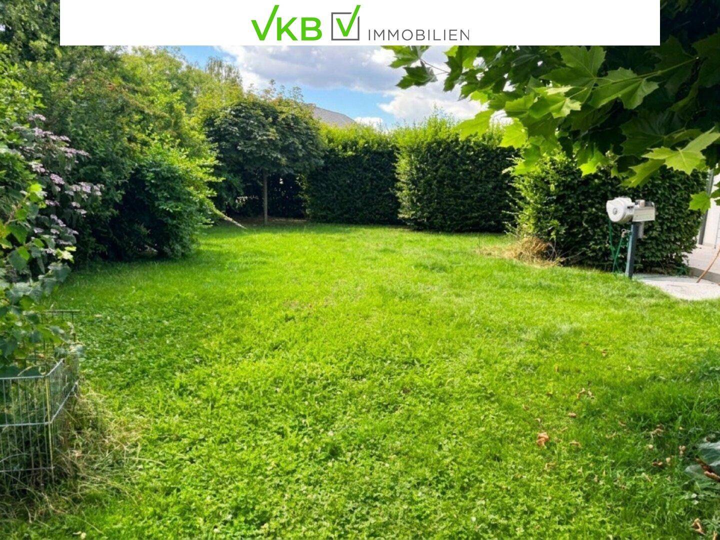 Gepflegter grüner Garten mit Rasenfläche und hohen Hecken für Privatsphäre.