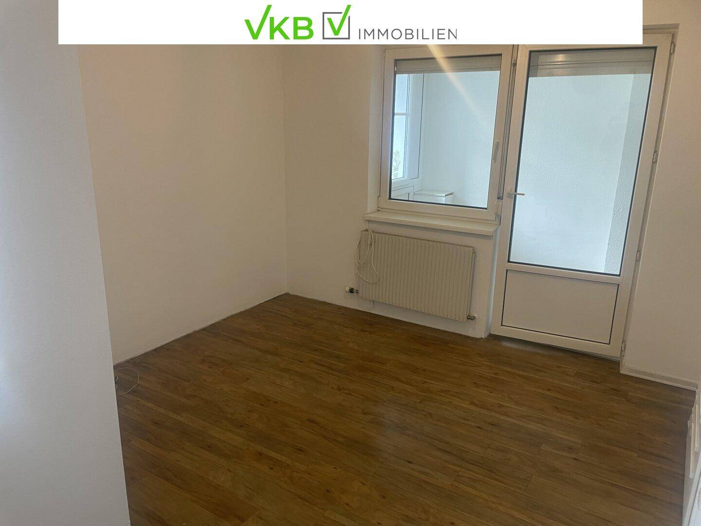 Helles Zimmer mit Laminatboden und direktem Zugang zu einem Balkon oder Wintergarten.