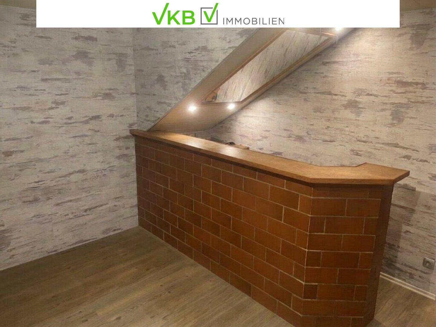 Gemütlicher Barbereich im Keller mit Ziegelsteinverkleidung und Holztheke.
