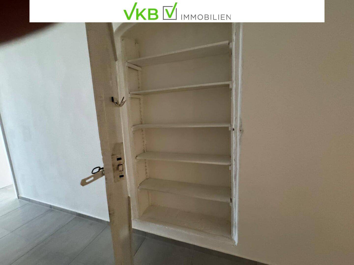 Offener Wandschrank mit Regalböden, ideal für zusätzlichen Stauraum im Eingangsbereich.