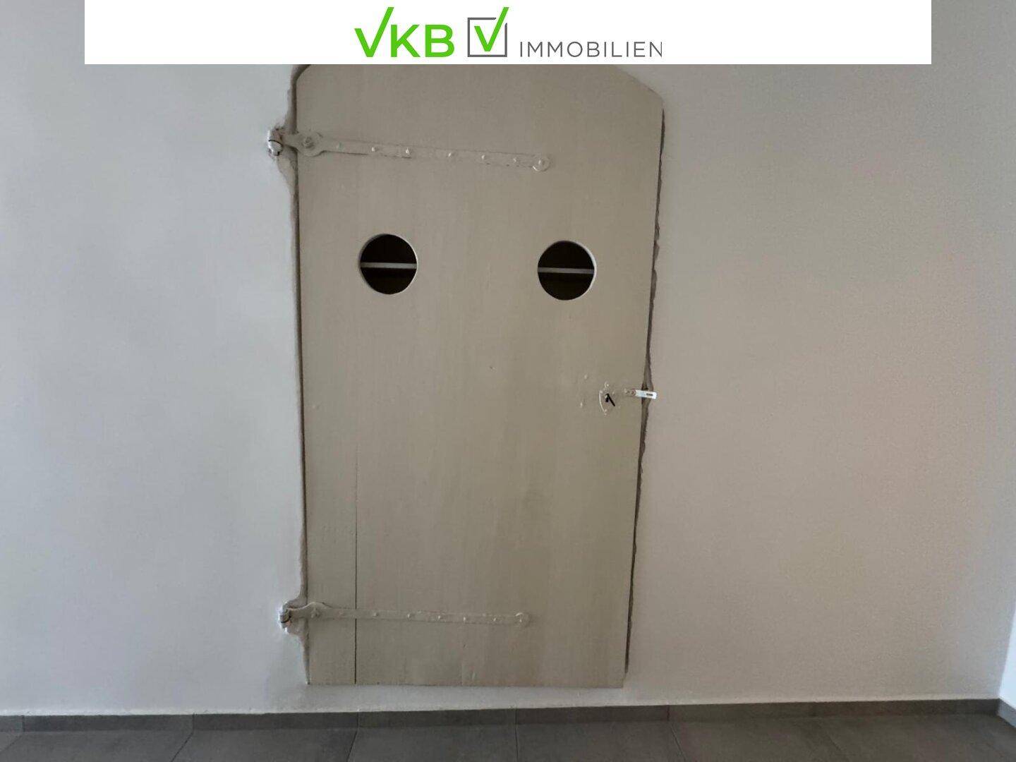Geschlossener Wandschrank mit zwei runden Öffnungen, der Stauraum im Flur bietet.