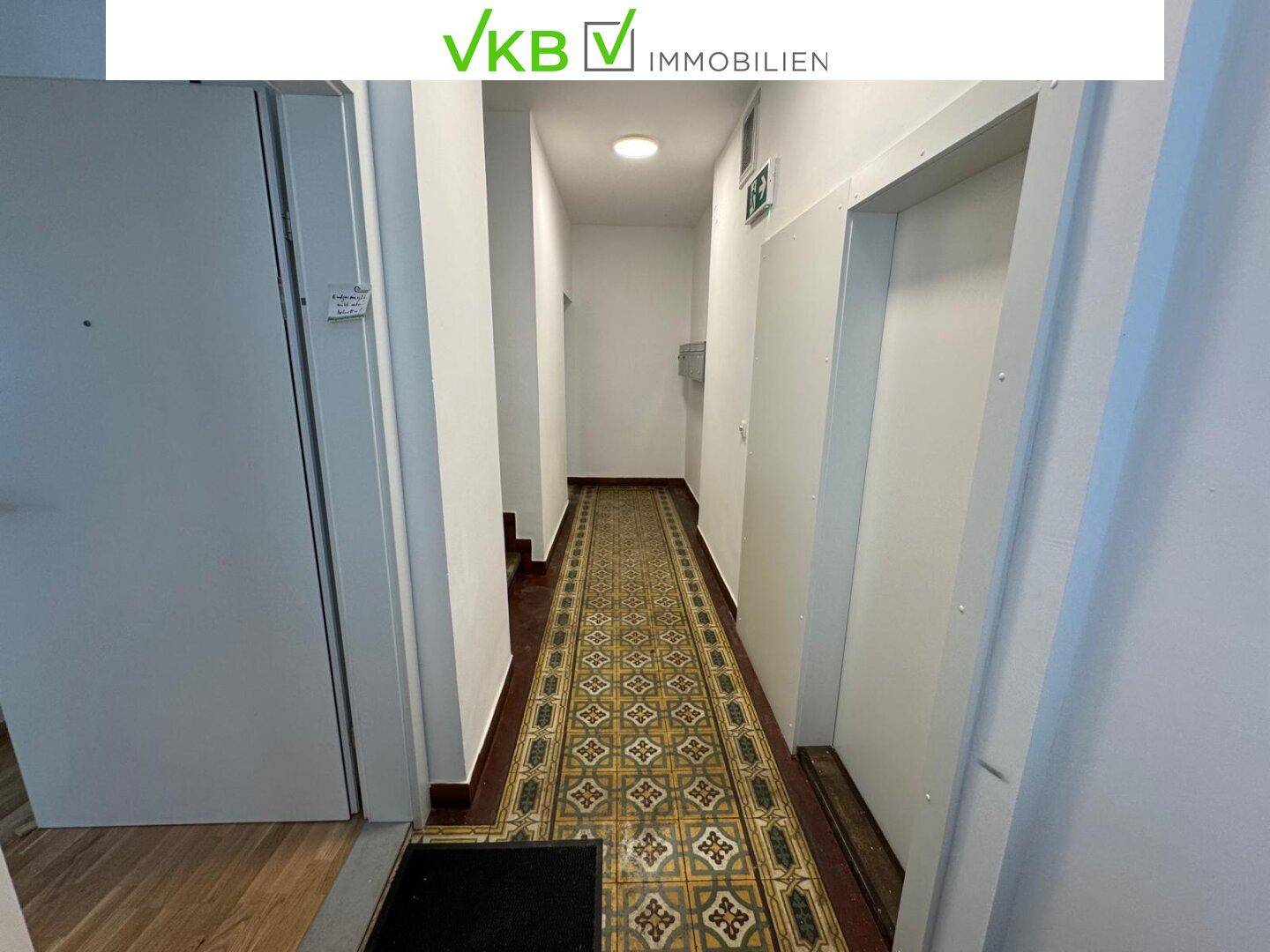 Eingangsbereich mit gemustertem Fliesenboden und Zugang zu verschiedenen Räumen im Gebäude.