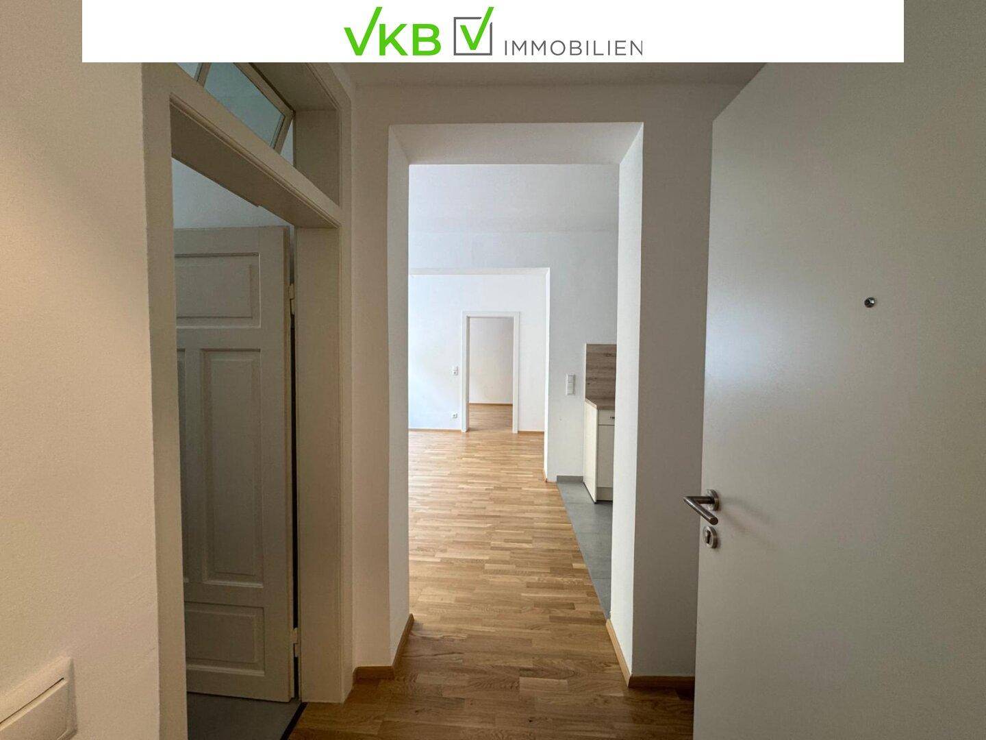 Flur mit Holzboden, der den Zugang zu den angrenzenden Wohnbereichen und der Küche ermöglicht.