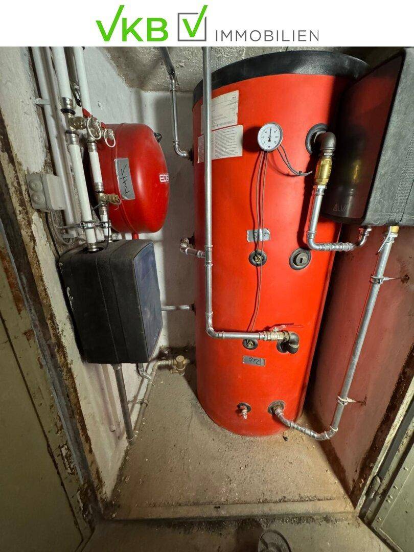 Technikraum mit Warmwasserspeicher und Rohrleitungen, die die Versorgung des Gebäudes sicherstellen.