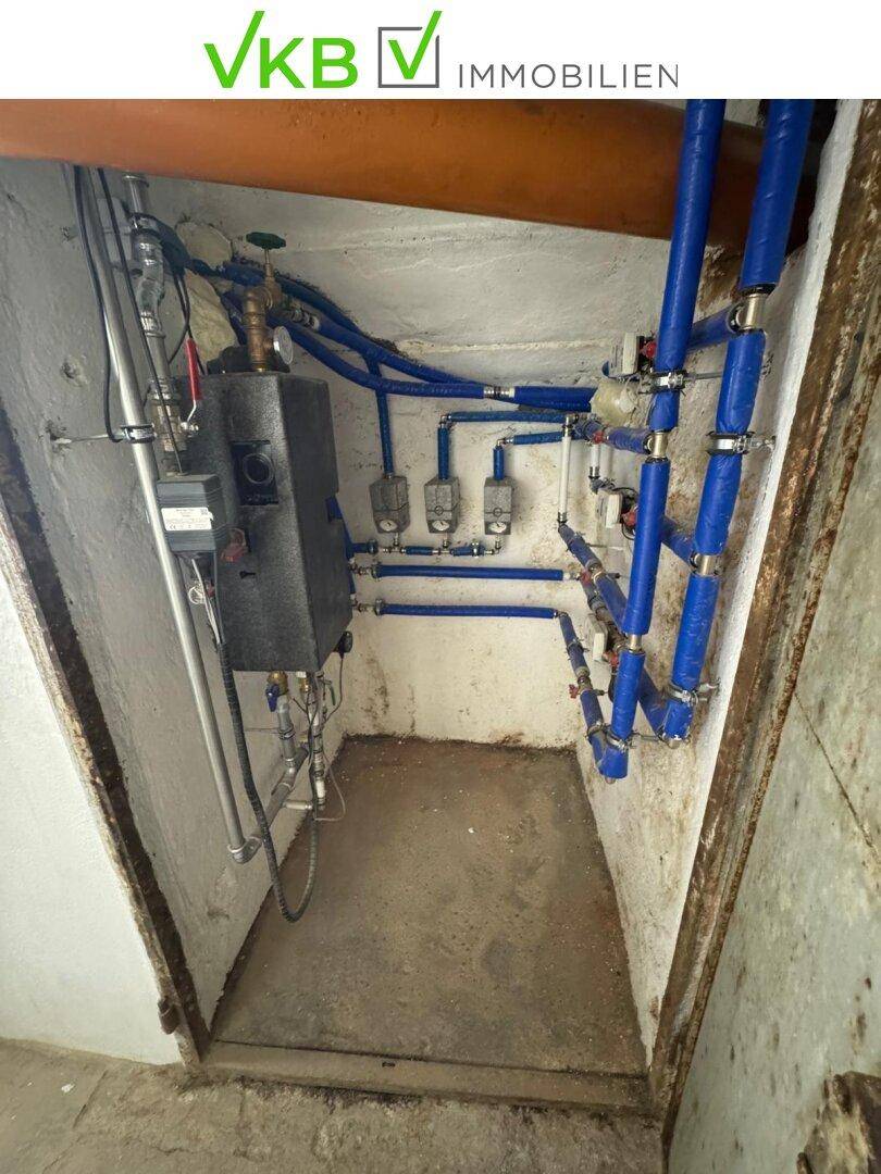 Kleiner Technikraum mit blauen Rohrleitungen und Installationen für die Wasserversorgung.