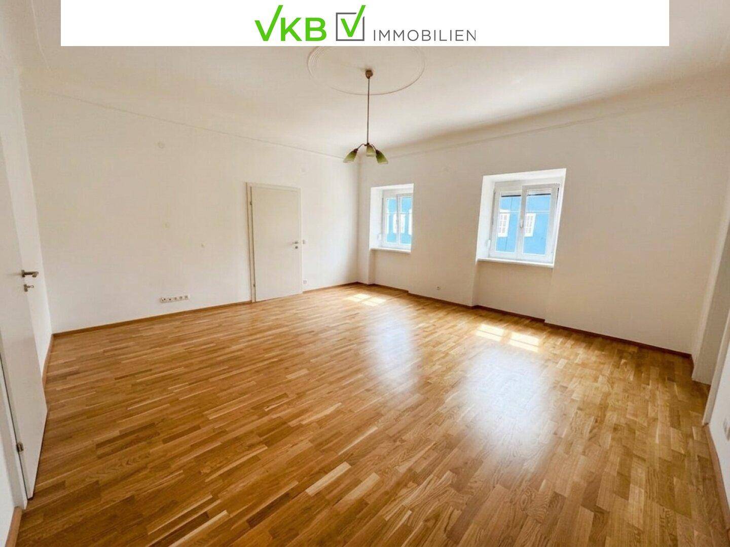 Geräumiges Wohnzimmer mit Parkettboden und Stuckdecke, bereit für die individuelle Einrichtung.