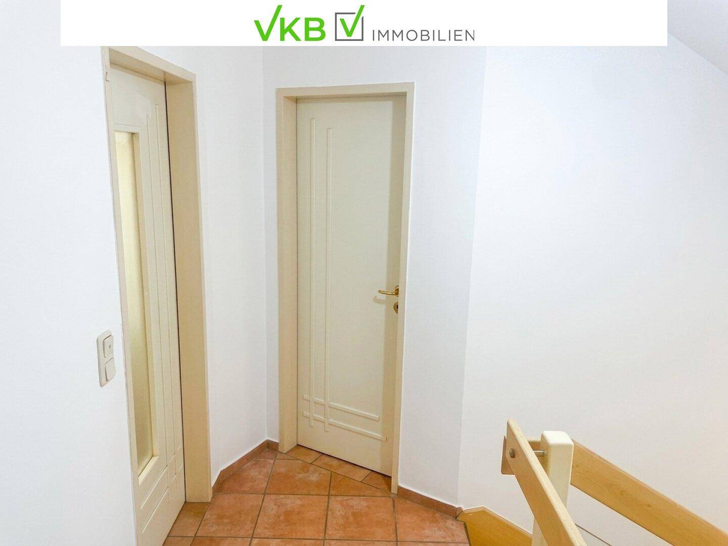 Schlichter Flur mit Fliesenboden und Zugang zu verschiedenen Räumen im Obergeschoss.