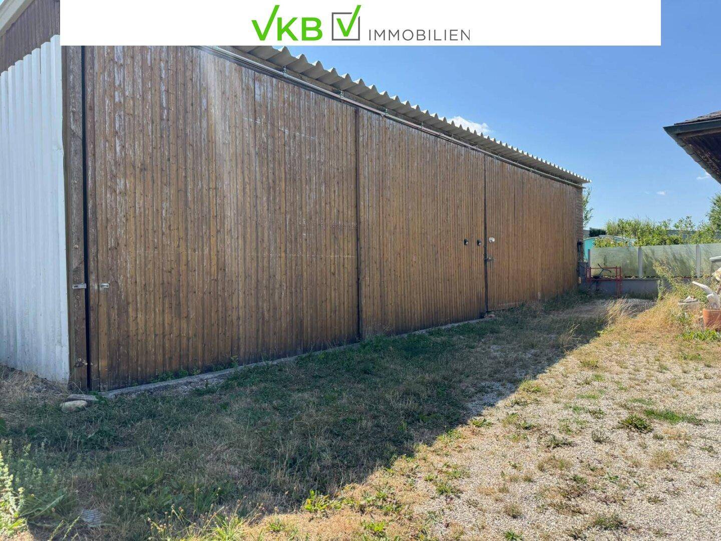 Lange, holzverkleidete Scheune oder Lagerhalle mit einfacher Dachkonstruktion im Außenbereich.