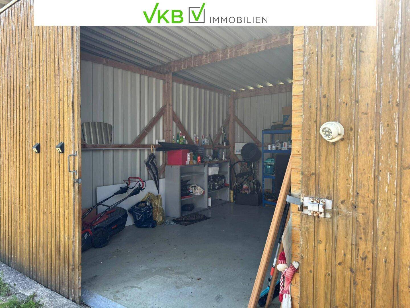 Innenansicht der Holzscheune mit Wellblechwänden und -dach, genutzt als Lagerraum für Geräte.