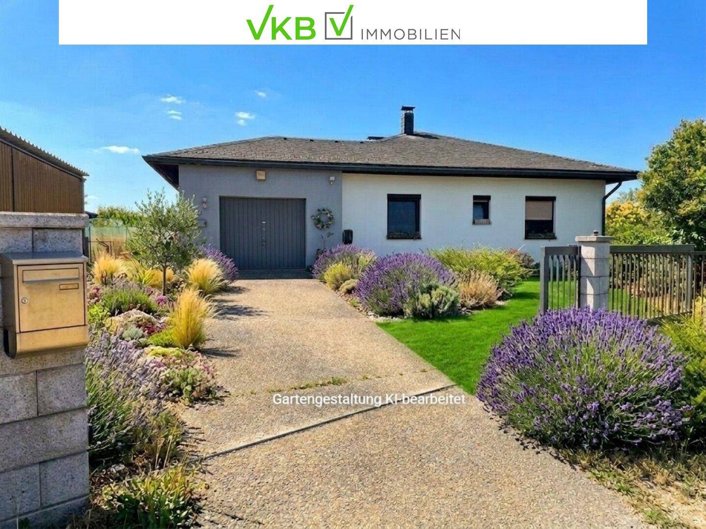 Vorderansicht eines Einfamilienhauses mit gepflegtem Vorgarten, Zufahrt und integrierter Garage unter blauem Himmel.