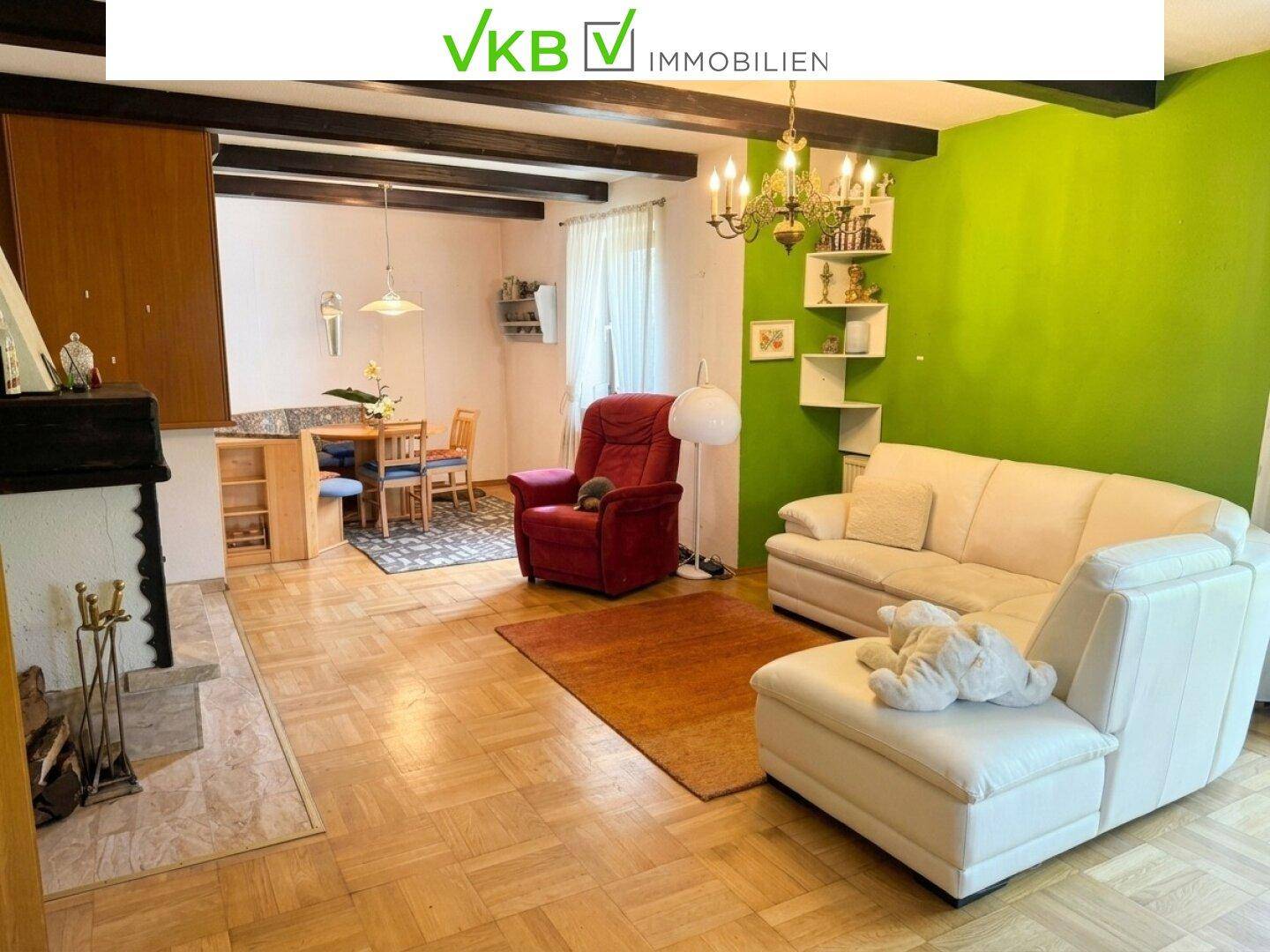 Geräumiger Wohn-Essbereich mit Kamin, Holzbalken und bequemen Sofas, ideal für gesellige Abende.