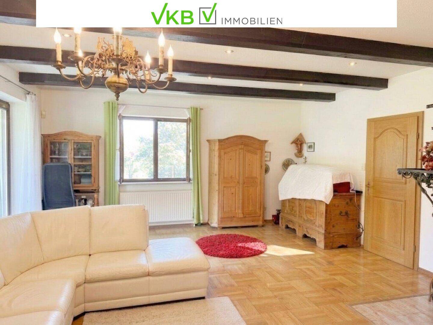 Helles Wohnzimmer mit Holzbalken, Parkettboden und traditionellen Möbeln, bietet viel Platz zum Entspannen.