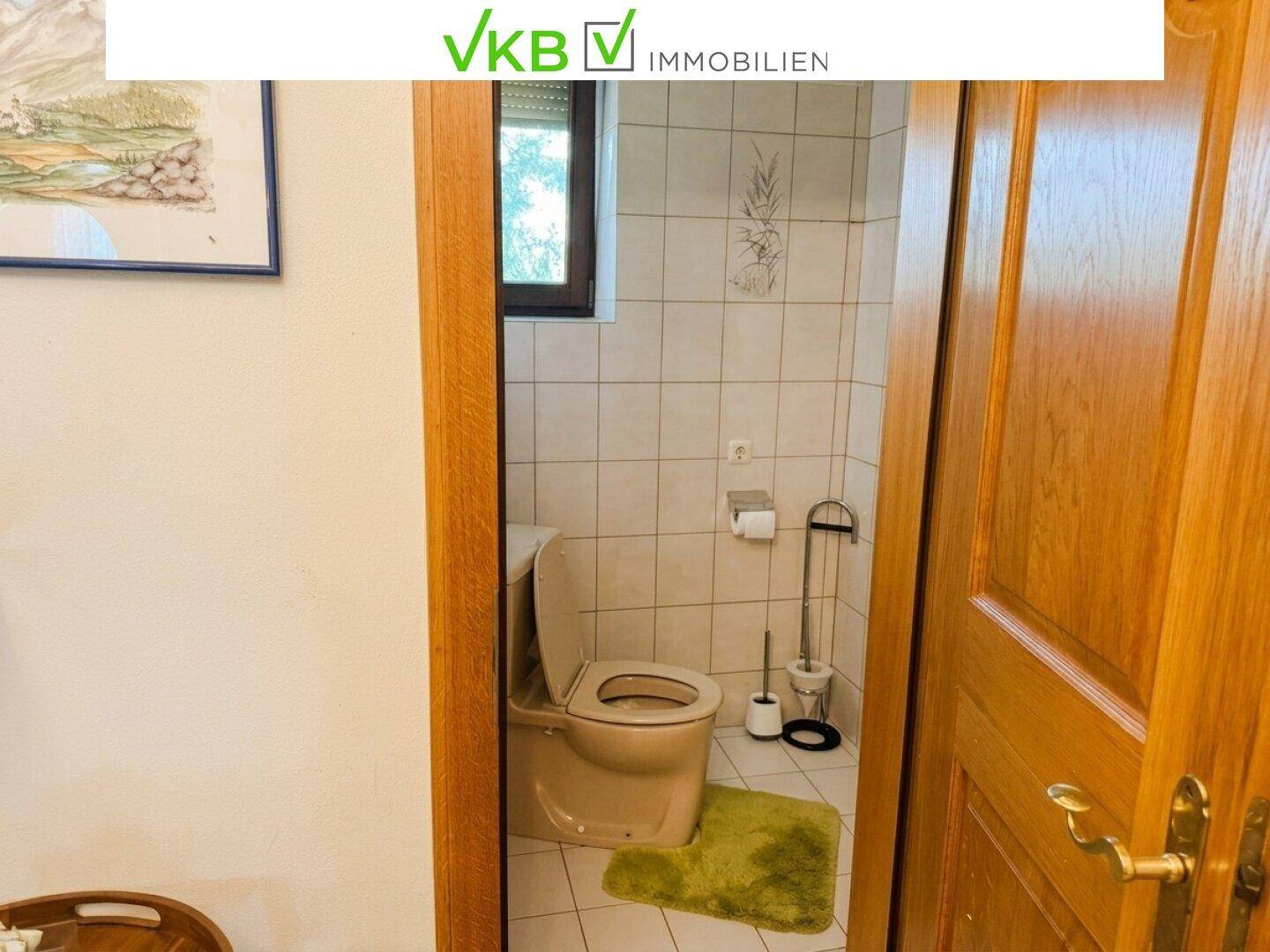 Einfaches Gäste-WC mit Toilette und Fliesenboden, funktional und pflegeleicht.