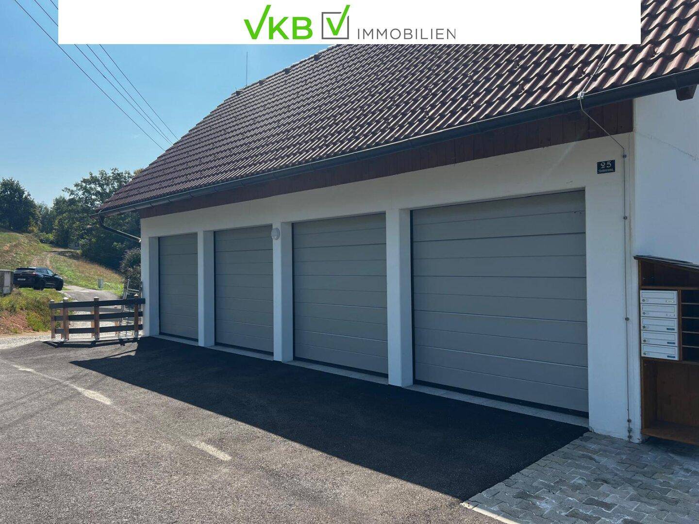 Mehrere Garagen mit modernen Rolltoren und Zufahrt.