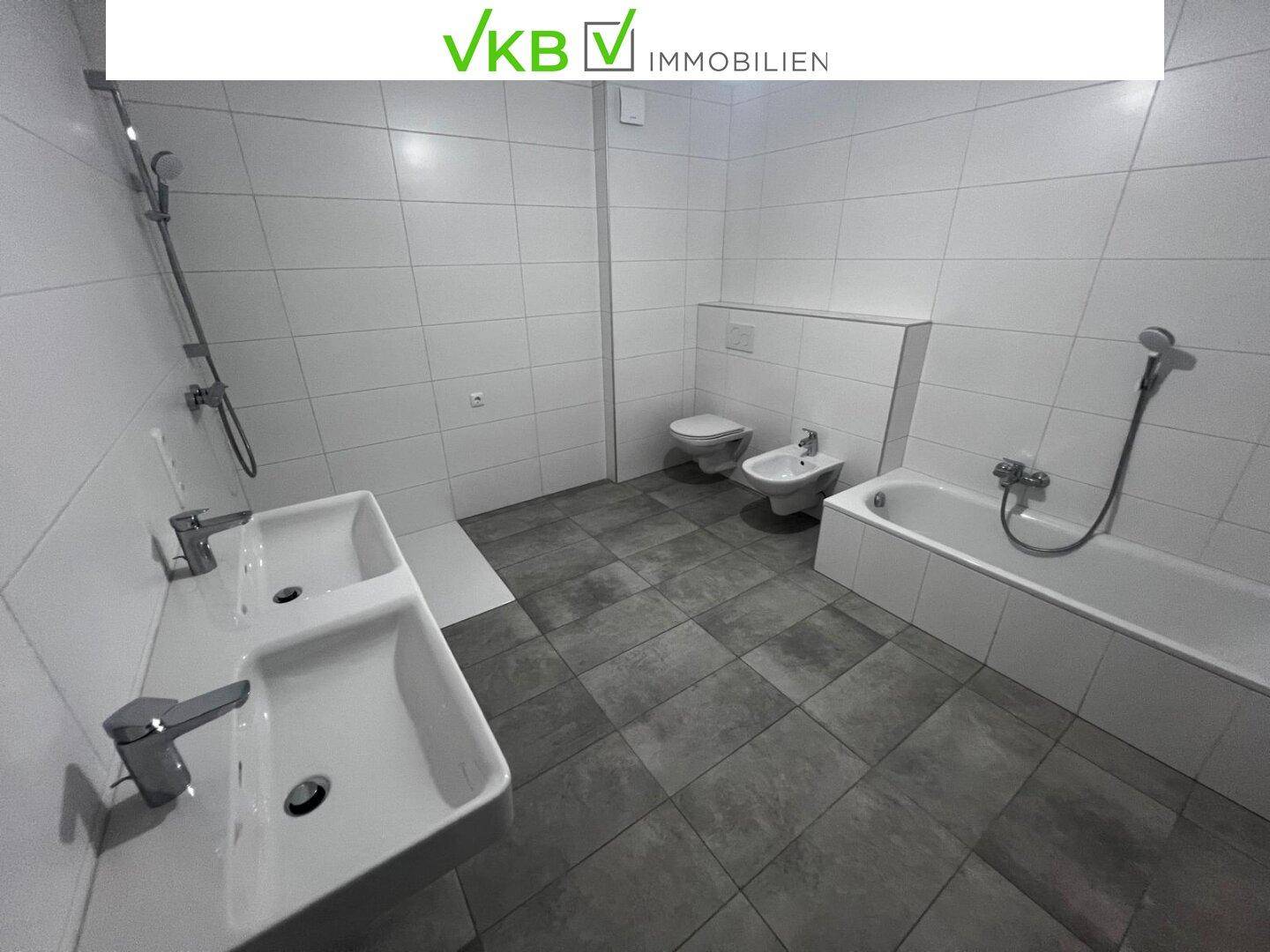Geräumiges Badezimmer mit Doppelwaschbecken, Badewanne, Dusche, WC und Bidet.