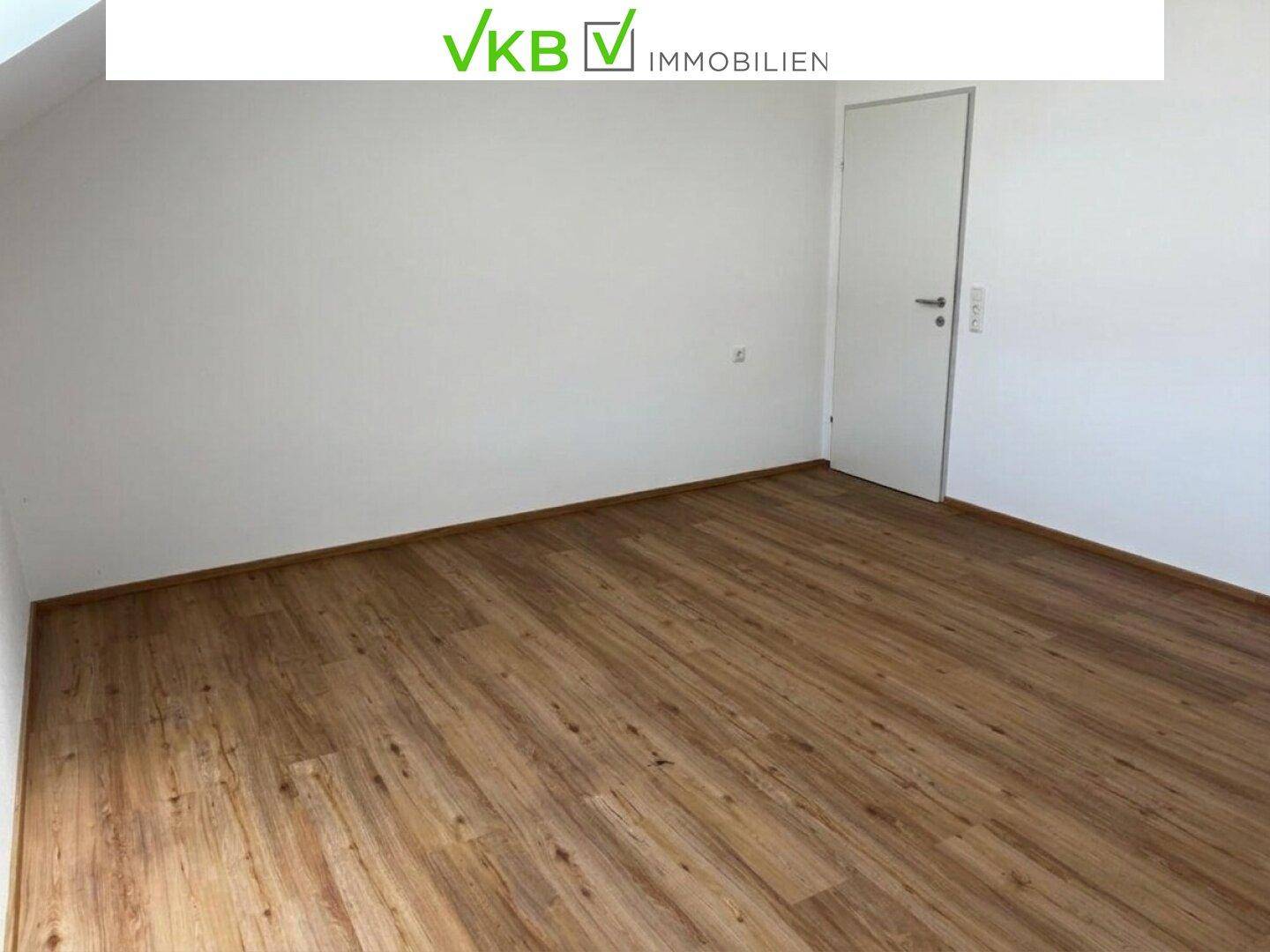 Leeres Schlafzimmer mit Laminatboden und weißen Wänden, bereit zur Einrichtung.