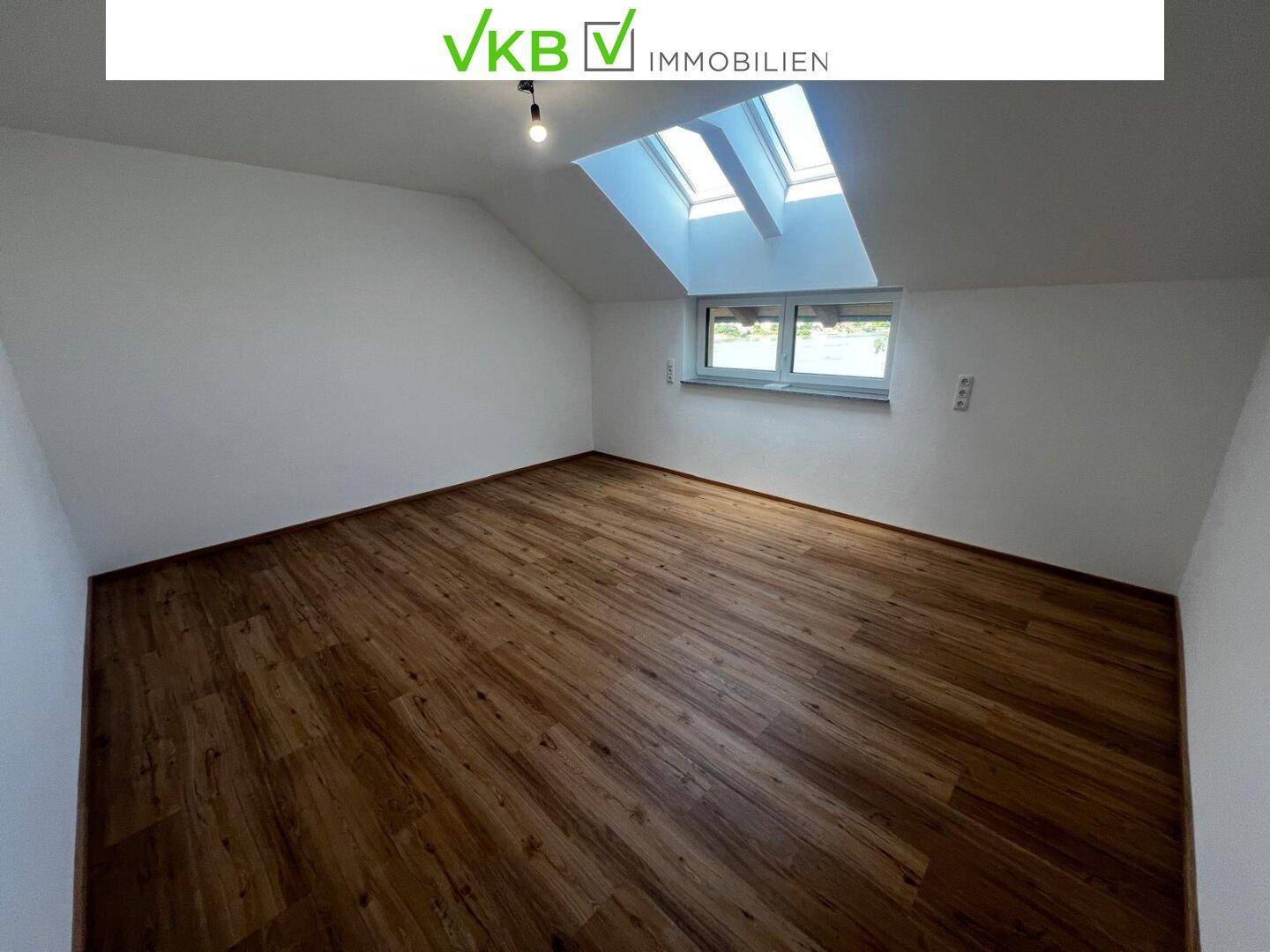 Helles Schlafzimmer mit Laminatboden, Dachschrägen und Dachfenstern für viel Licht.