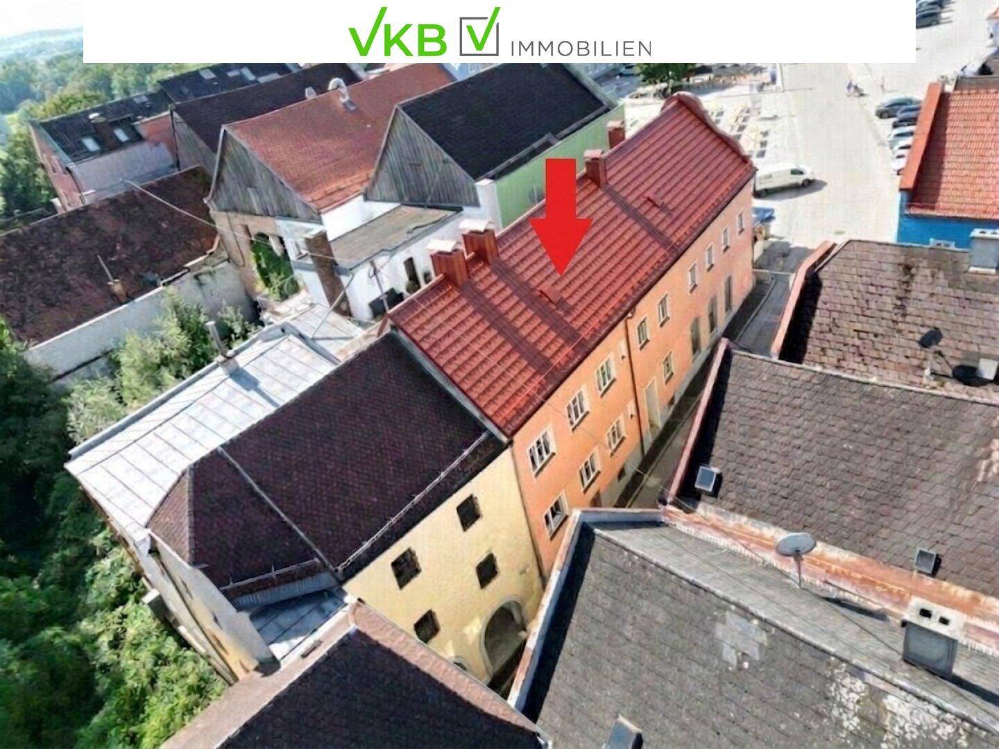 Vogelperspektive des Gebäudes mit rotem Ziegeldach und angrenzenden historischen Häusern in der Altstadt.