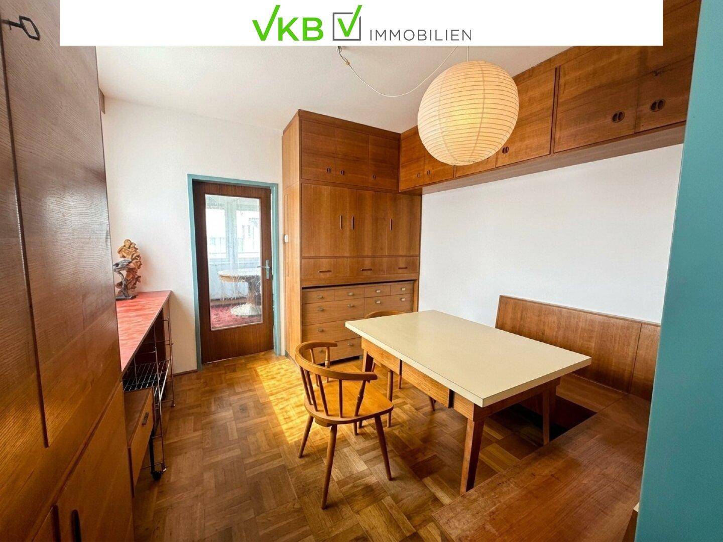 Esszimmer mit Holztisch, Stühlen und eingebauten Holzschränken, die viel Stauraum bieten.