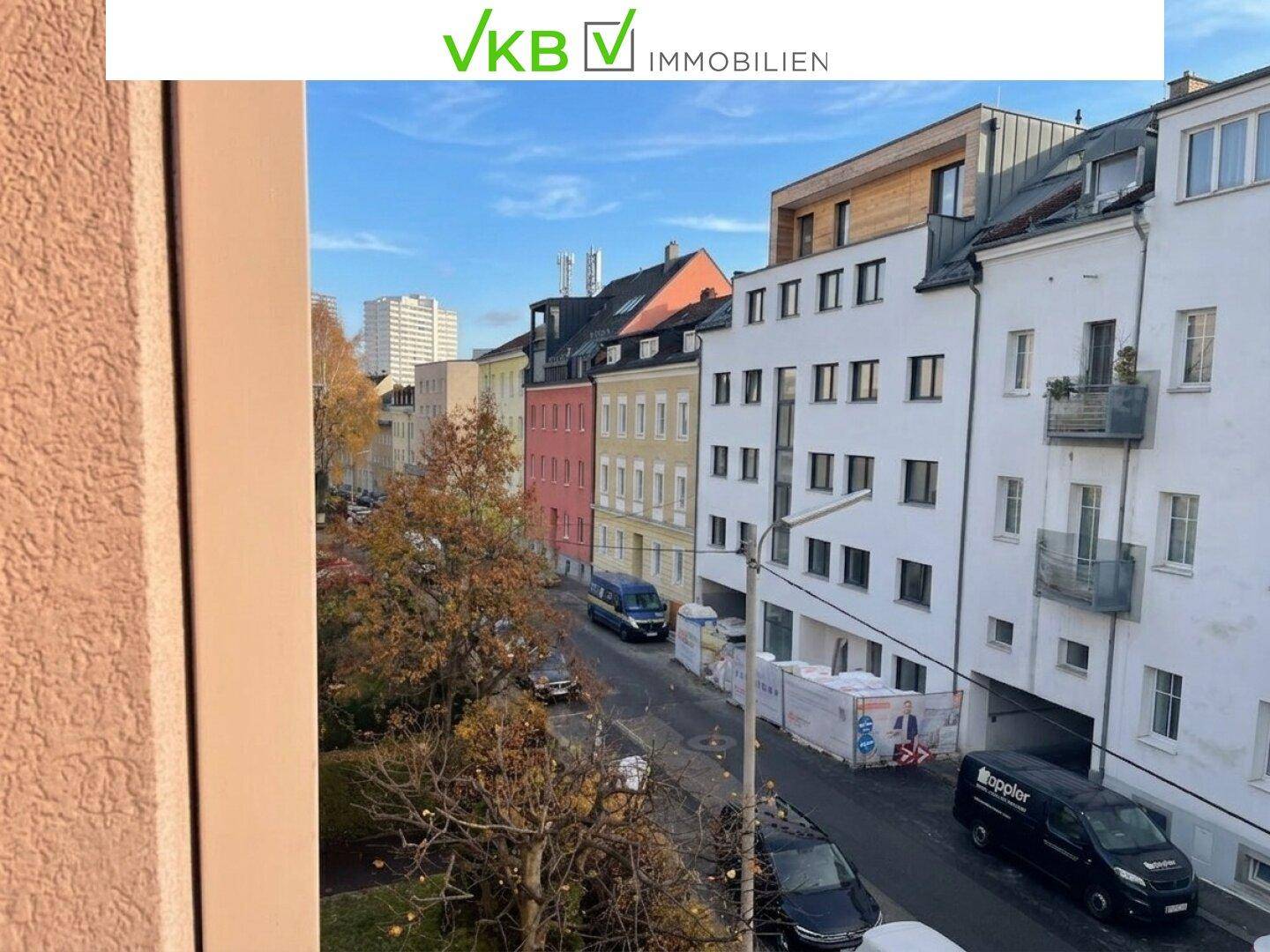 Balkon mit weitem Blick über die Stadt und die umliegenden Gebäude unter blauem Himmel.