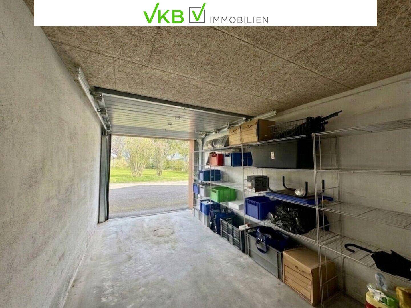 Geräumige Garage mit Regalen und Lagerboxen, die zusätzlichen Stauraum bietet.