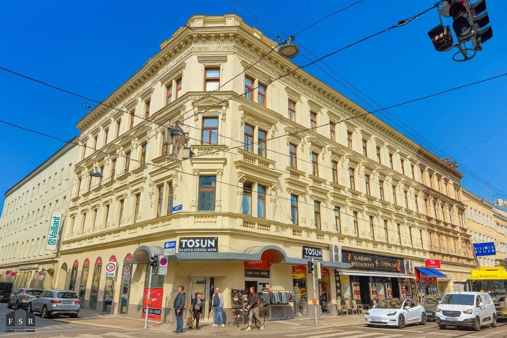 Eindrucksvolles Eckgebäude mit klassischer Architektur und reich verzierten Fassadendetails in urbaner Umgebung.