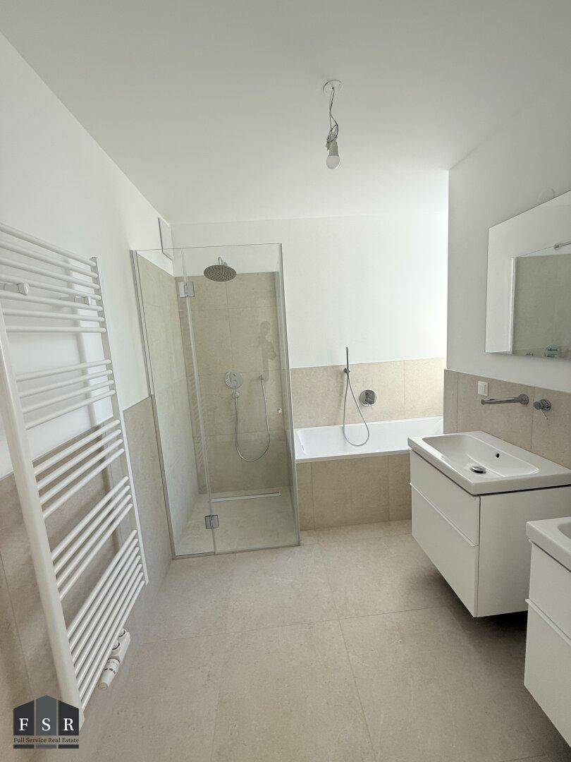 Modernes Badezimmer mit begehbarer Dusche, Badewanne und Doppelwaschbecken.