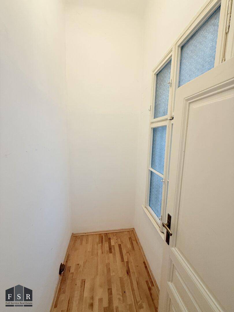 Kleiner Raum mit Laminatboden und Fenster, ideal als Abstellraum oder begehbarer Kleiderschrank.
