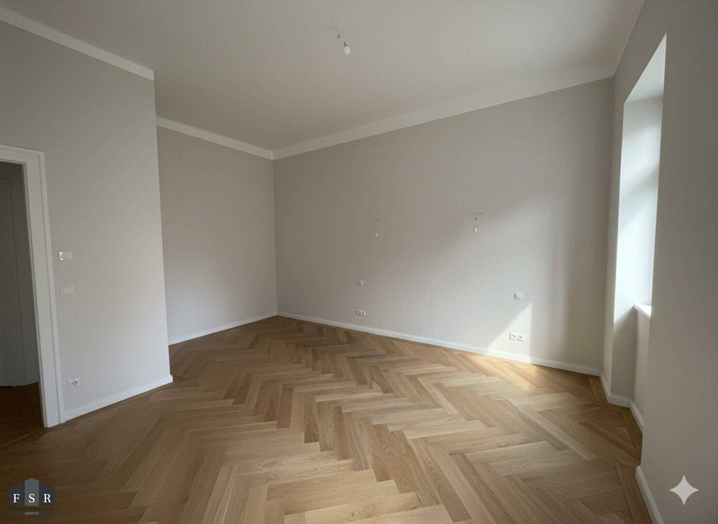 Lichtdurchfluteter Raum mit Fischgrätparkett und hohen Decken, ideal für ein Wohn- oder Schlafzimmer.