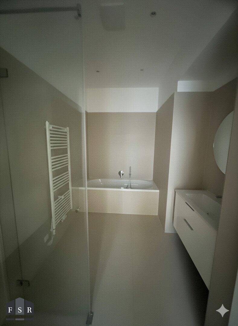 Modernes Badezimmer mit Badewanne, Duschbereich und elegantem Waschtisch mit Einzelwaschbecken.