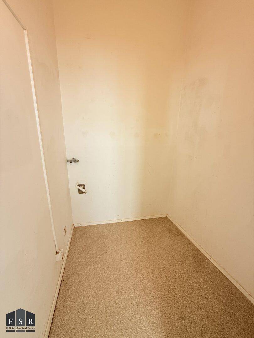 Leerer Abstellraum mit Teppichboden und Anschlüssen an der Wand, ideal für Lagerung und vielseitig nutzbar.