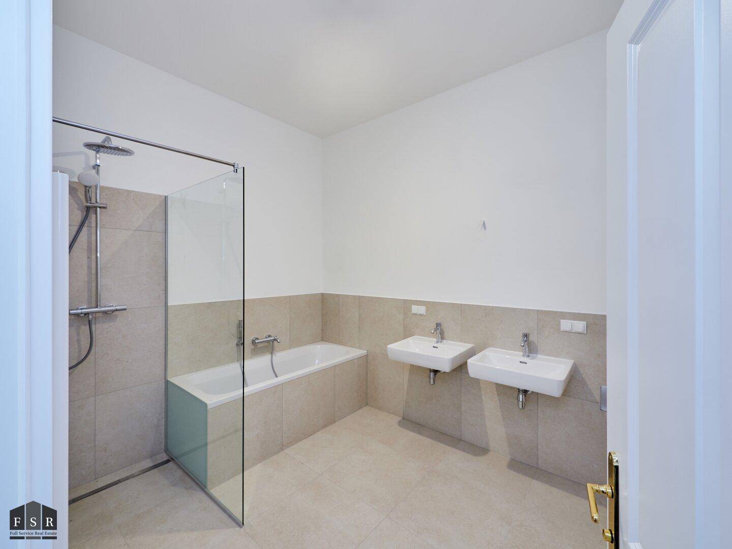 Modernes Badezimmer mit zwei Waschbecken, Badewanne und Duschbereich mit Glasabtrennung.