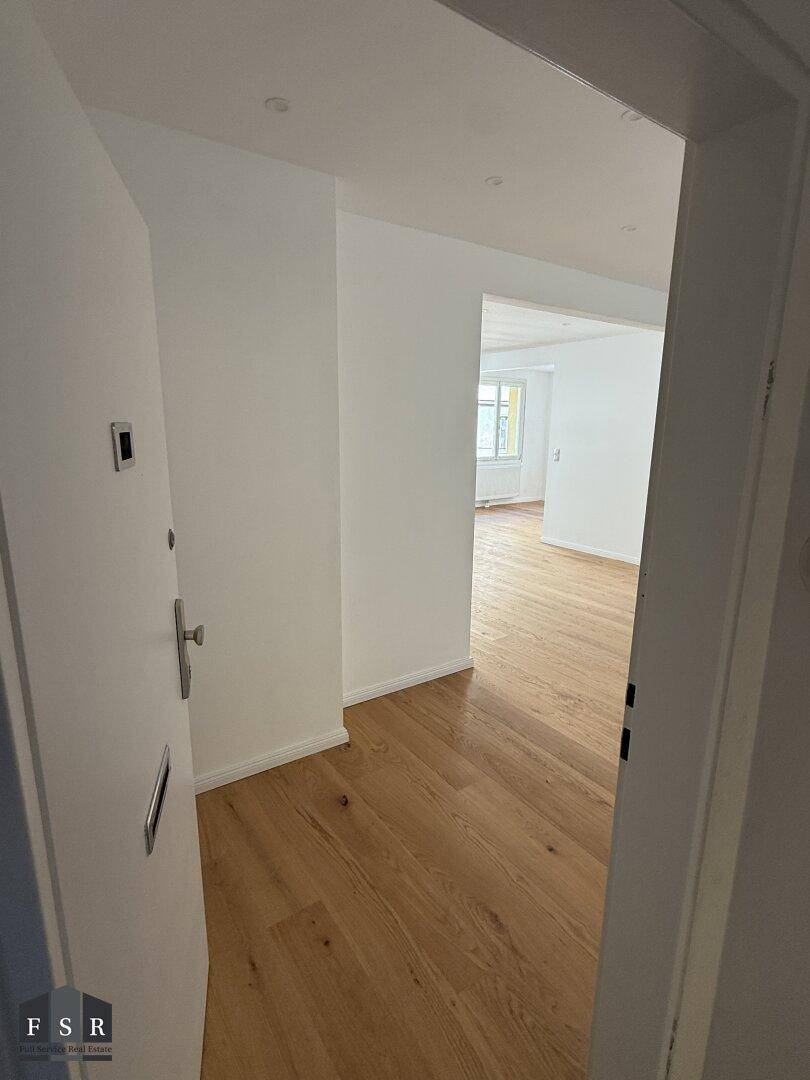 Heller Eingangsbereich mit Holzboden und Zugang zu den weiteren Räumen der Wohnung.