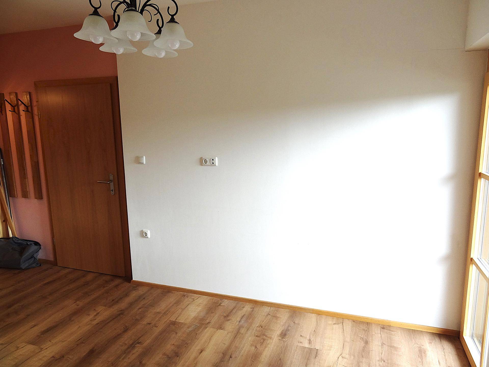 Heller Raum mit Laminatboden und Deckenleuchte, bereit zur individuellen Gestaltung.