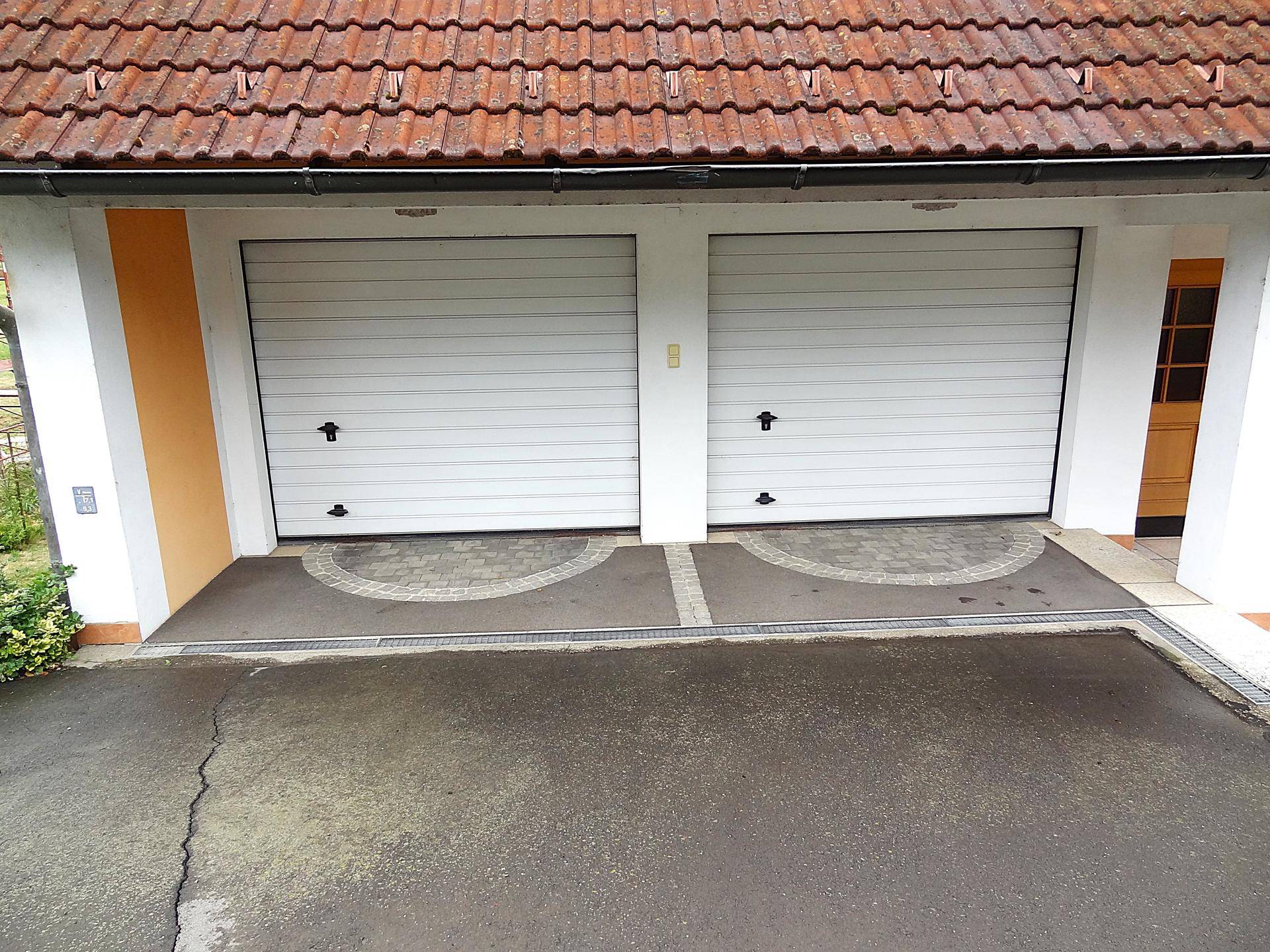Nahaufnahme der beiden weißen Garagentore, die zur Doppelgarage führen.