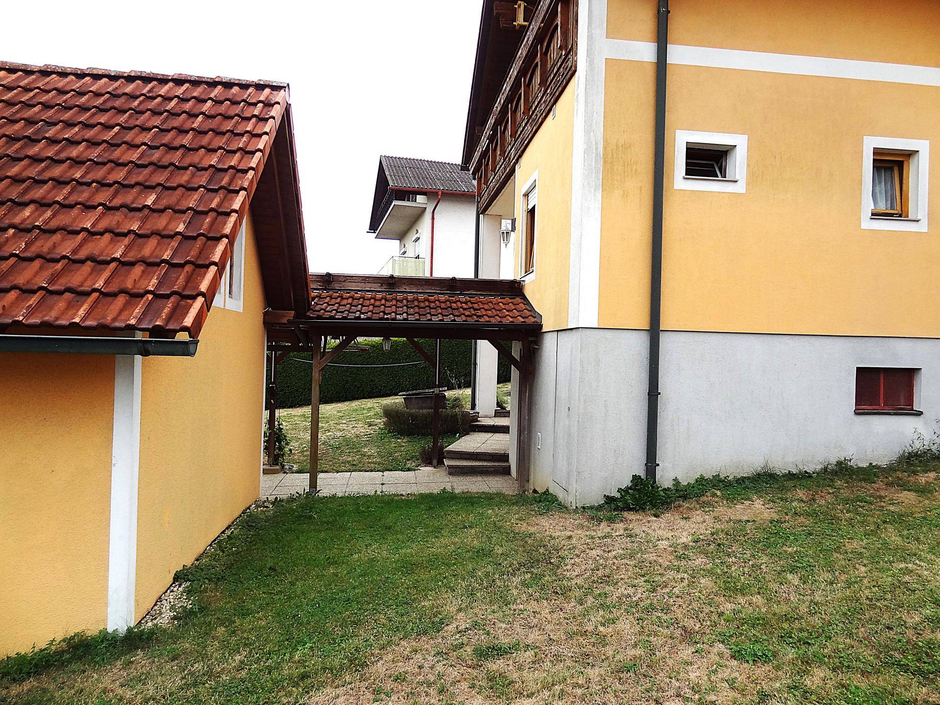 Überdachter Gang verbindet zwei Gebäudeteile und führt in den Garten.