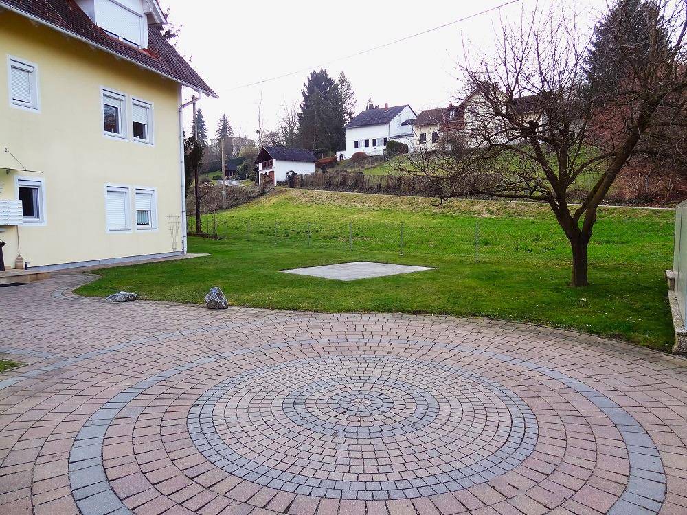 Außenansicht des Gebäudes mit weitläufiger Rasenfläche und Blick auf die grüne Landschaft.