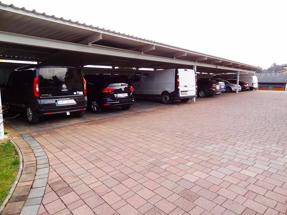 Carport mit zahlreichen Stellplätzen für Fahrzeuge, alle unter einem schützenden Dach.